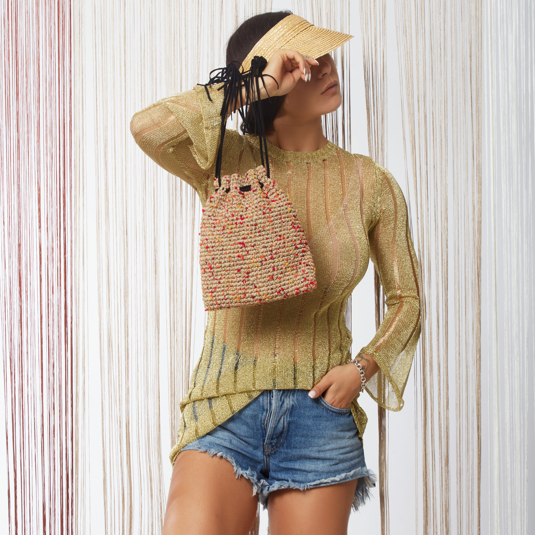 girl hols a mini handmade pouch crochet bag in sand beige color